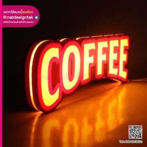 ป้ายไฟคำว่า COFFEE สีส้มแดงเรืองแสง วางบนพื้นมืด