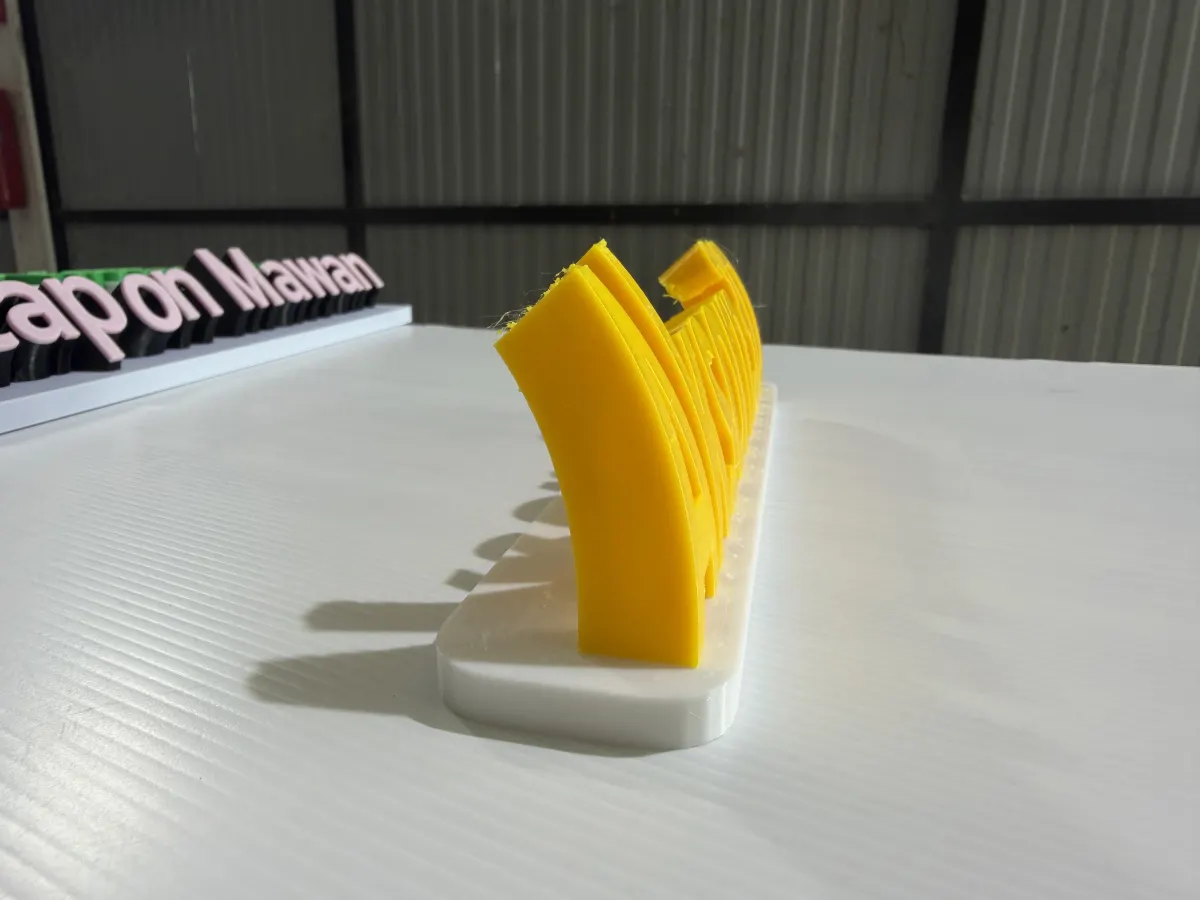 มุมข้างป้าย Aksorn3D สีเหลืองบนฐานขาว แสดงความลึกและฐานบานของฟังก์ชั่น 3D mini