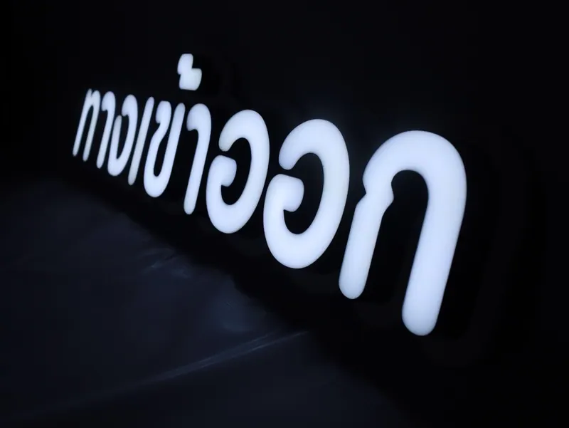ป้ายไฟภาษาไทยสีขาวบนพื้นหลังสีดำ ถ่ายมุมเฉียง