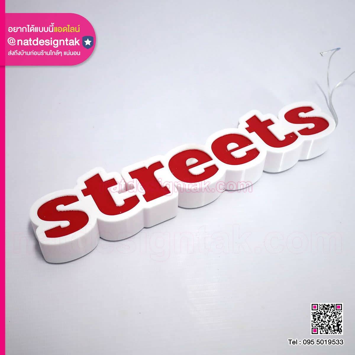 ป้ายคำว่า Streets ตัวอักษรสีแดง มีตัวเรือนสีขาว วางบนพื้นสีอ่อน