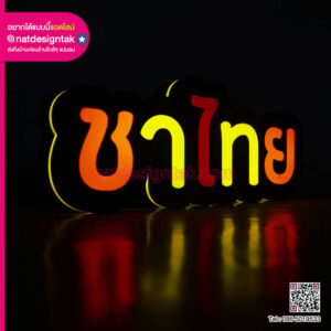 ป้ายไฟภาษาไทยคำว่า ชาไทย สีส้มและเหลืองบนพื้นหลังสีดำ